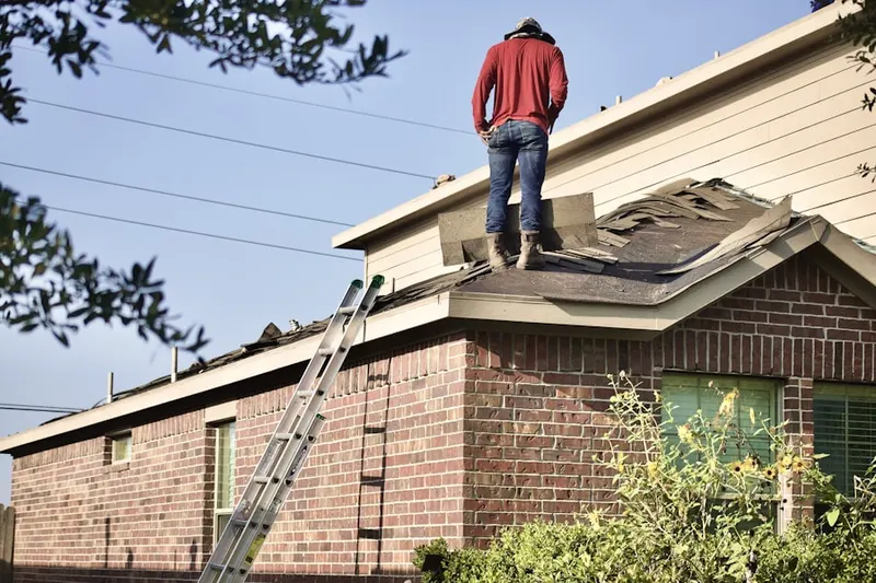 Professional roofer working on a residential roof in Quissett